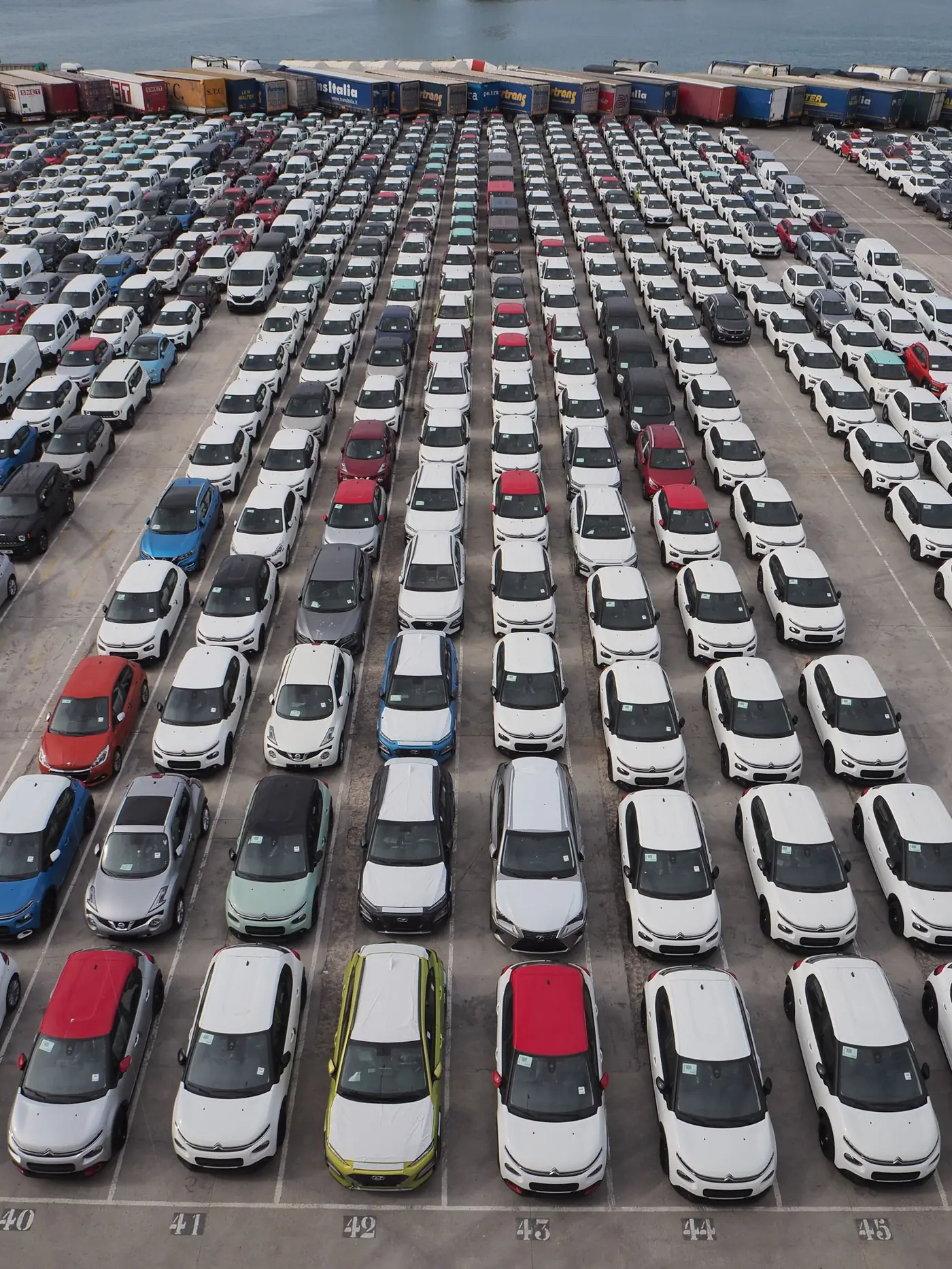 Rows of vehicles awaiting movement in a port precinct.